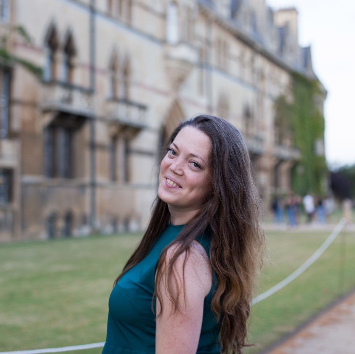 Woman smiling in front of university